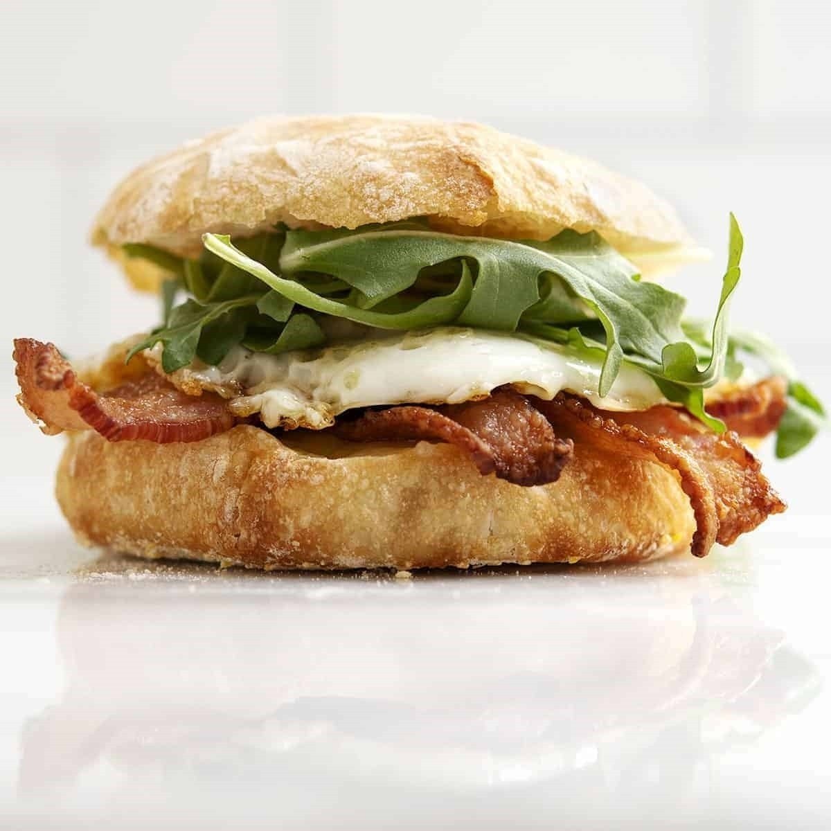 English Muffin Breakfast Sandwich With Bacon Fried Egg And Cheddar