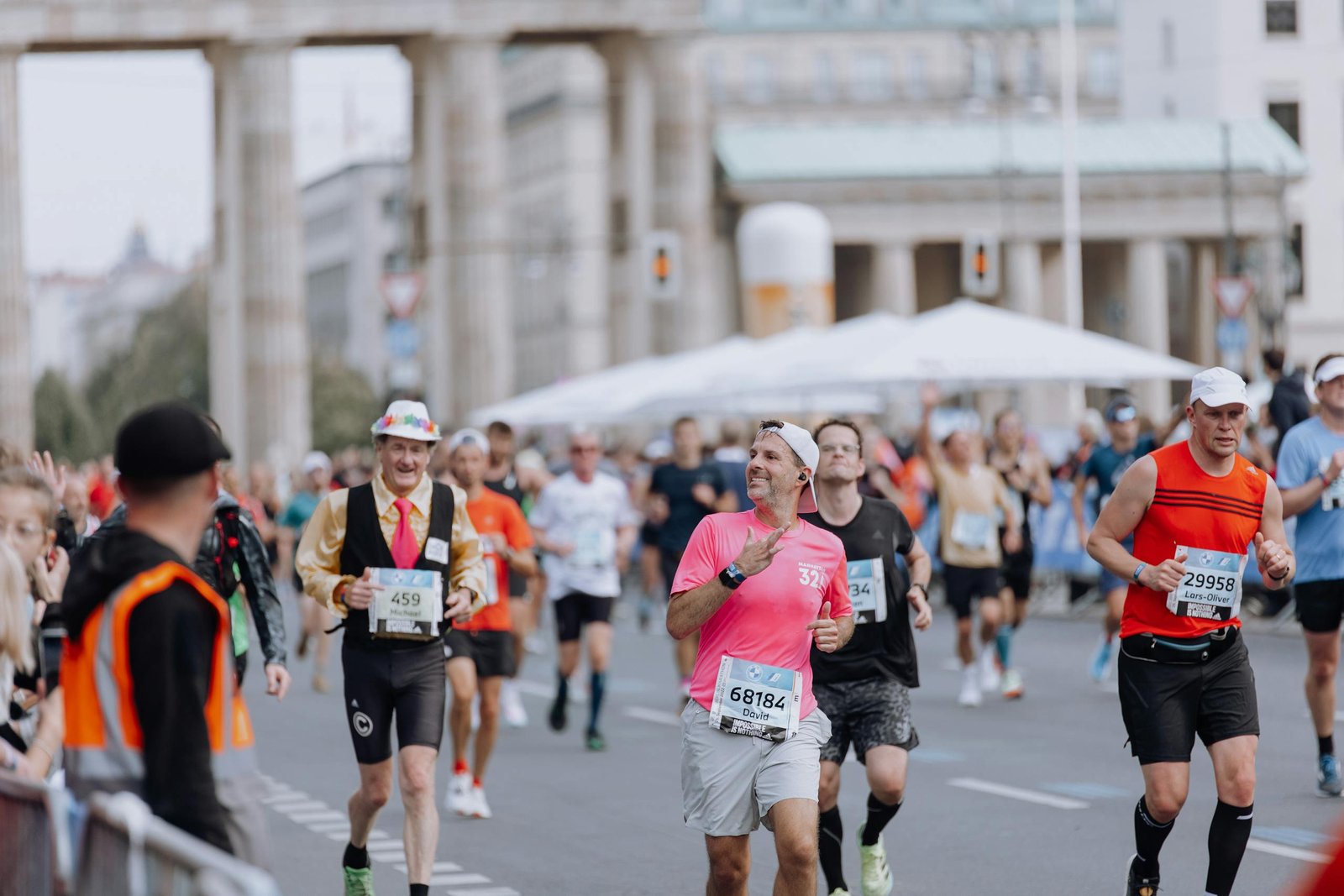 Diverse group of runners competing in marathon near iconic monument, capturing a lively and energetic atmosphere.