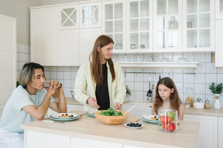 Family having breakfast together in a modern kitchen setting, showing connection and healthy eating.